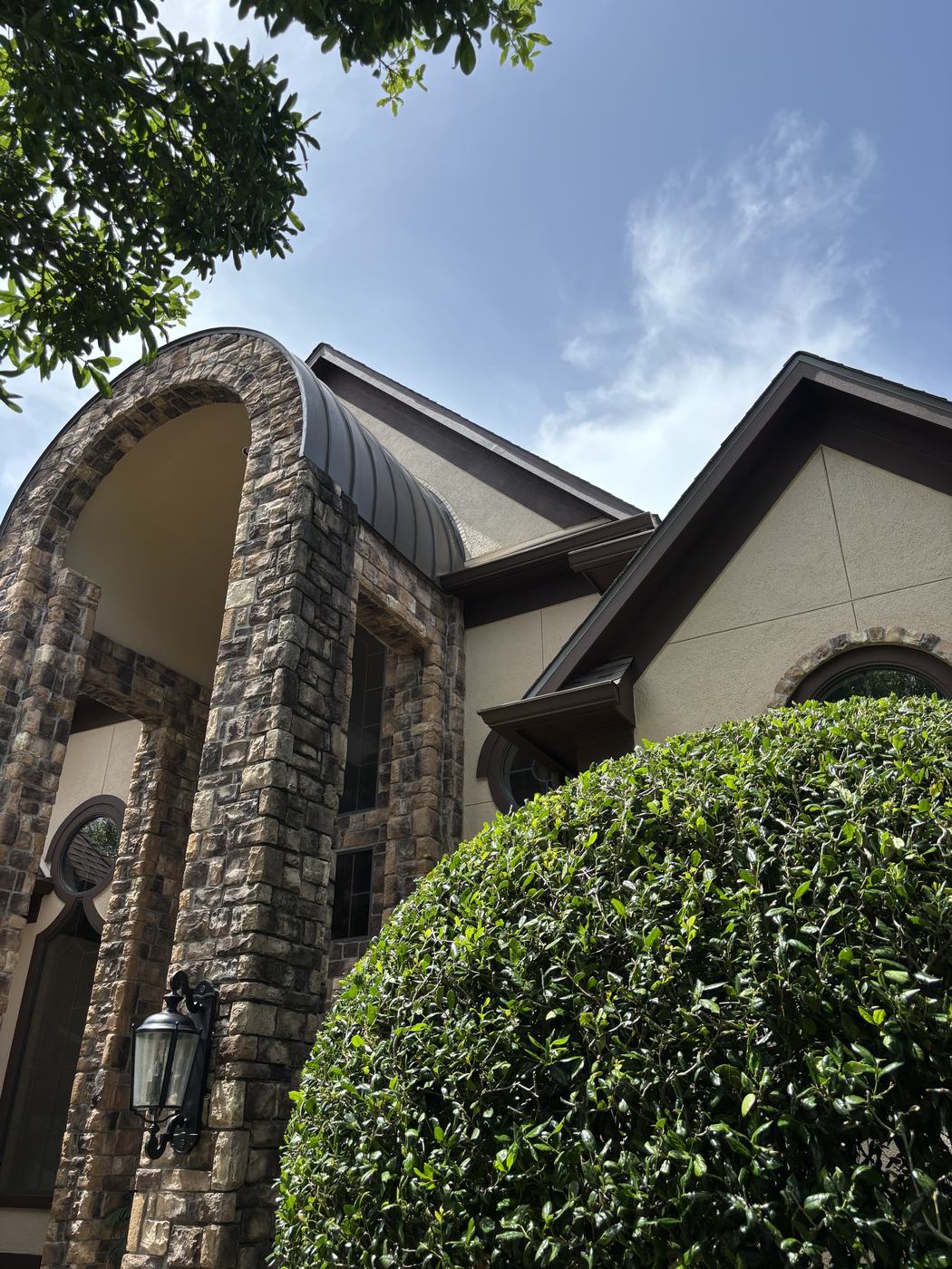 Exterior paint finished — stucco gable and stone archway