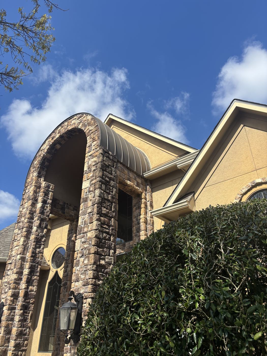 Exterior paint before — stucco gable and stone archway